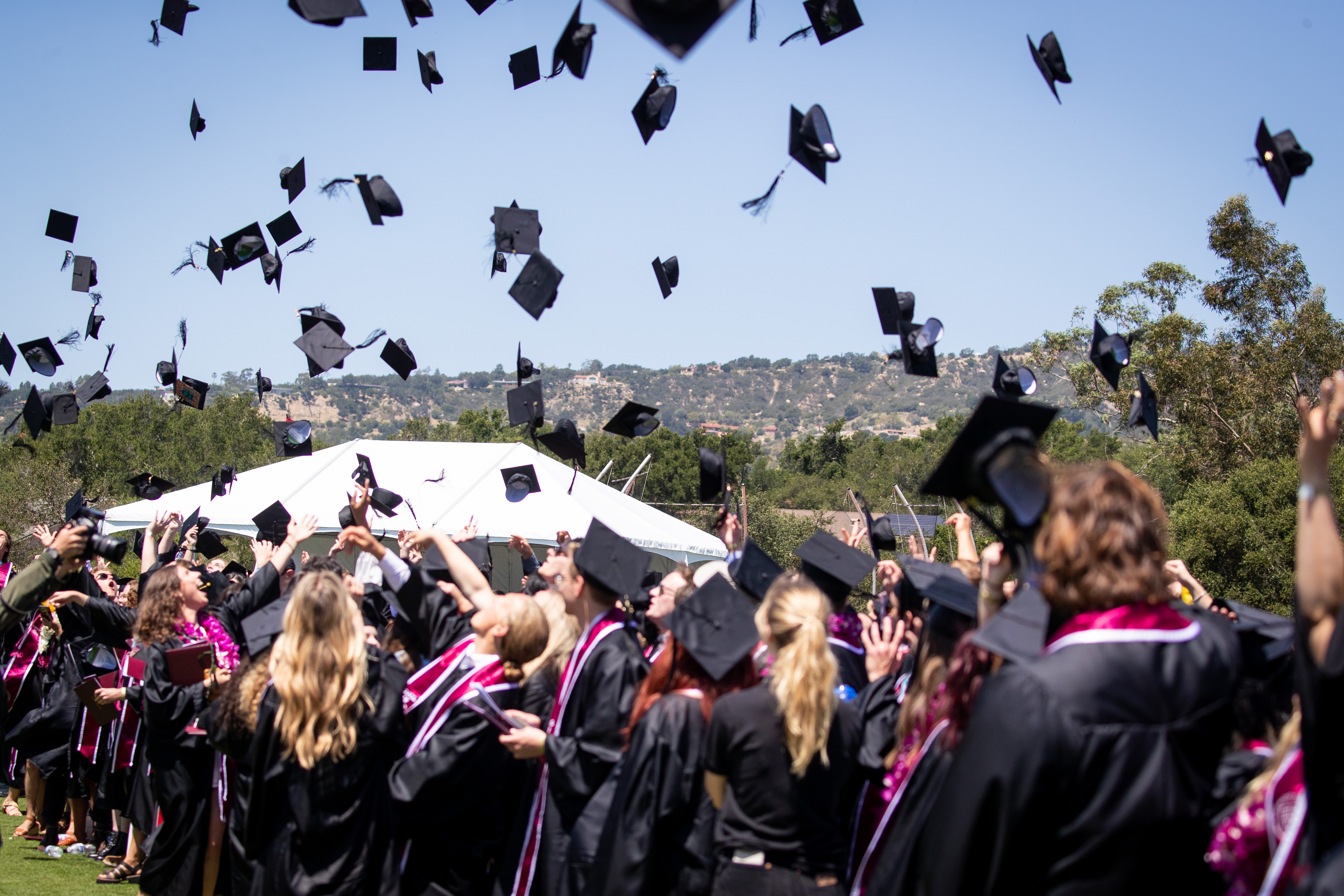 westmont graduates throwing caps in the air