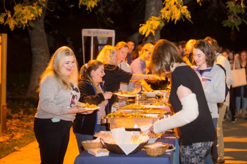 Students eat a catered meal in front of Murchison Gym