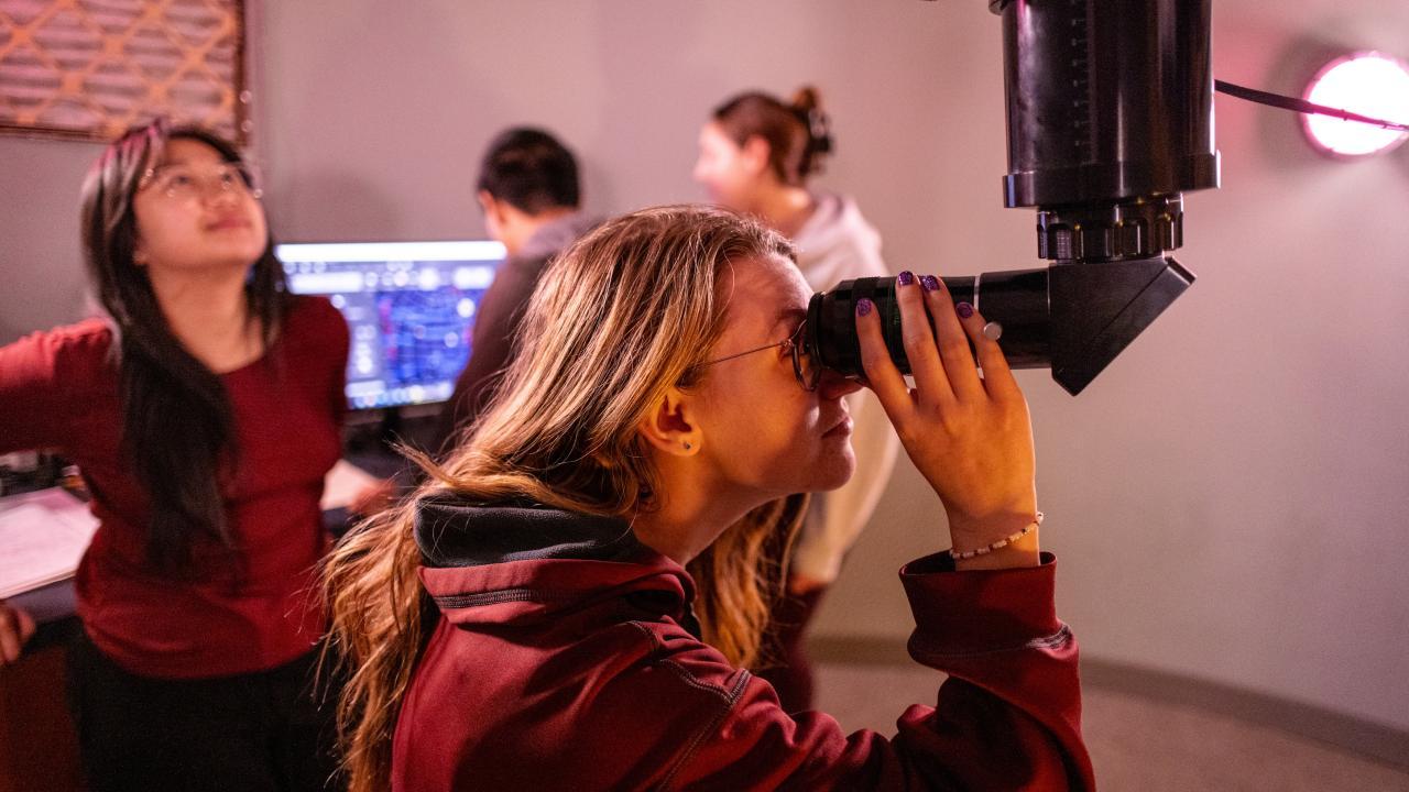 Astrophysics Minor students looks through telescope